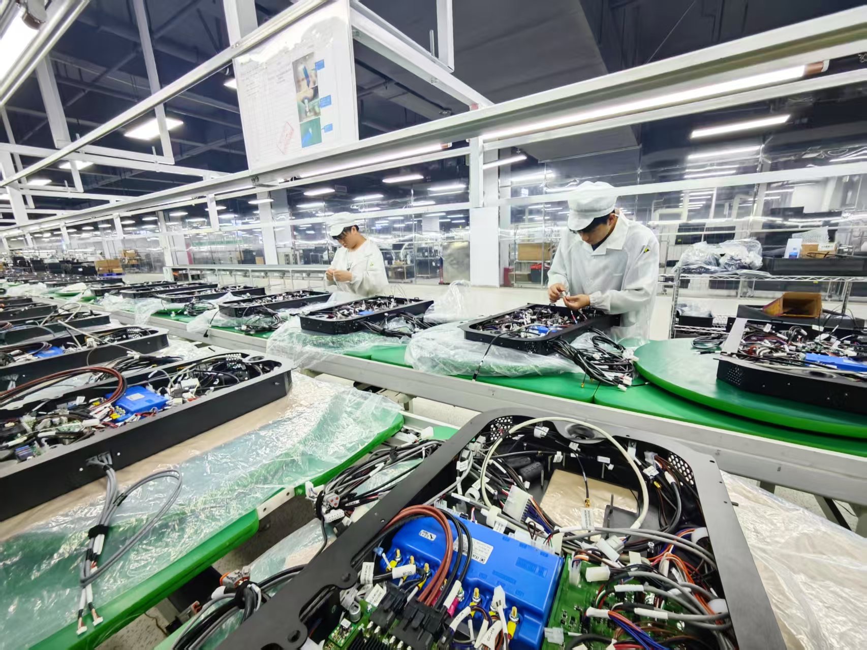 Workers on an assembly line alongside automated systems, illustrating the integration of human labor with smart manufacturing technologies